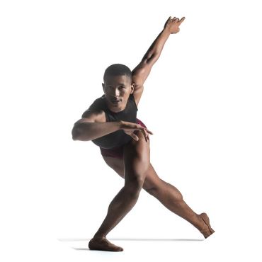 A dancer stands in front of a white background. They are crouched over and have their arms and legs pointed to the side. They are wearing a black and red leotard and are staring at the camera.