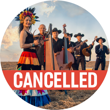 A woman in a back top, brightly colored skirt, wearing a tiara of brightly colored flowers and feathers holding animal horns, with the rest of the band wearing black hats holding their instruments stand behind her with a poppy colored "cancelled" banner over the image