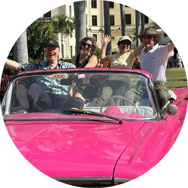 People having fun in a pink car with the top down.