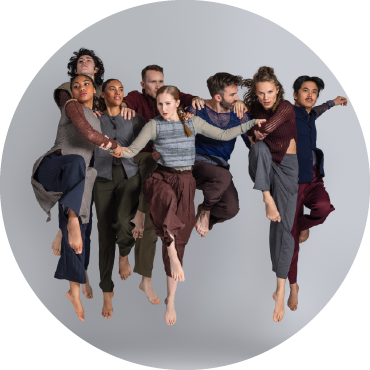 Several dancers leap into the air together against a grey background.