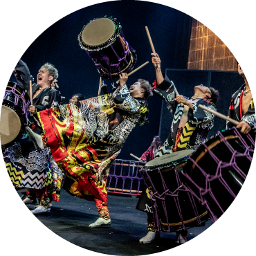 Drummers captured performing live with their drums while wearing colorful clothing