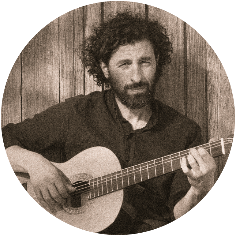José González plays the guitar and looks forward at the camera