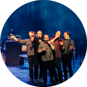 Members of Le Vent du Nord sing on stage.