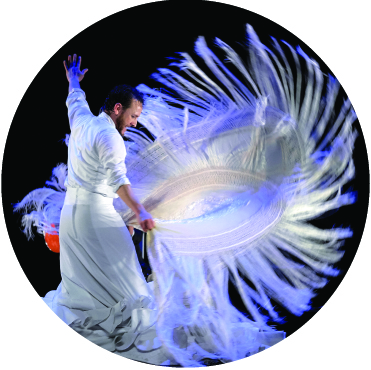 Manuel Linan twirling a fringe lined white flamenco shawl in a dramatic fashion