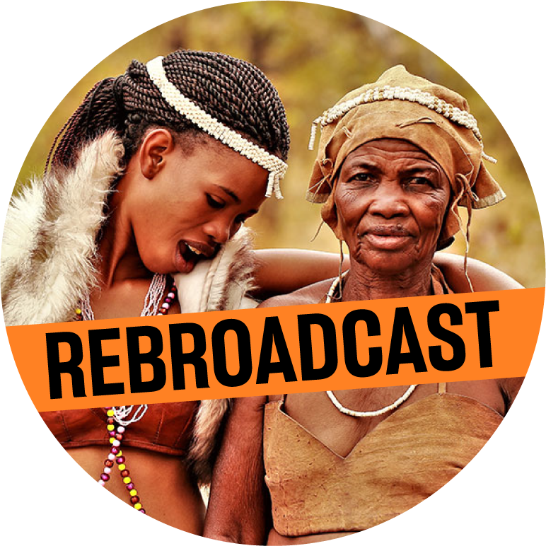 A bust shot of two women in a circle frame. They have dark skin. The women on the left is younger and has dark hair in braids, She has a white headband and necklace on and looks down towards the other woman's shoulder. The other woman is older and looks at the camera. She wears a tan scarf around her head, a white necklace, and a tan top. 