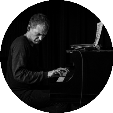 Brad Mehldau plays the piano in a black and white image