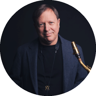 Chris Potter smiles and holds a saxophone