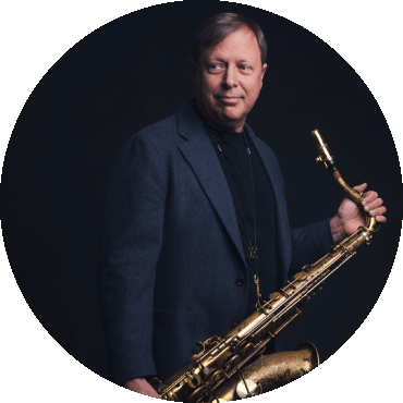 Chris Potter holds a saxophone while looking to the side