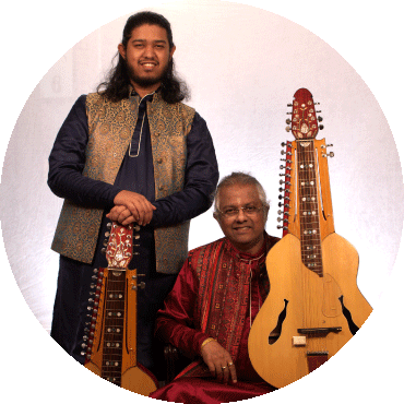 Debashish Bhattacharya and Suryadipta Bhattacharya smile and hold their instruments