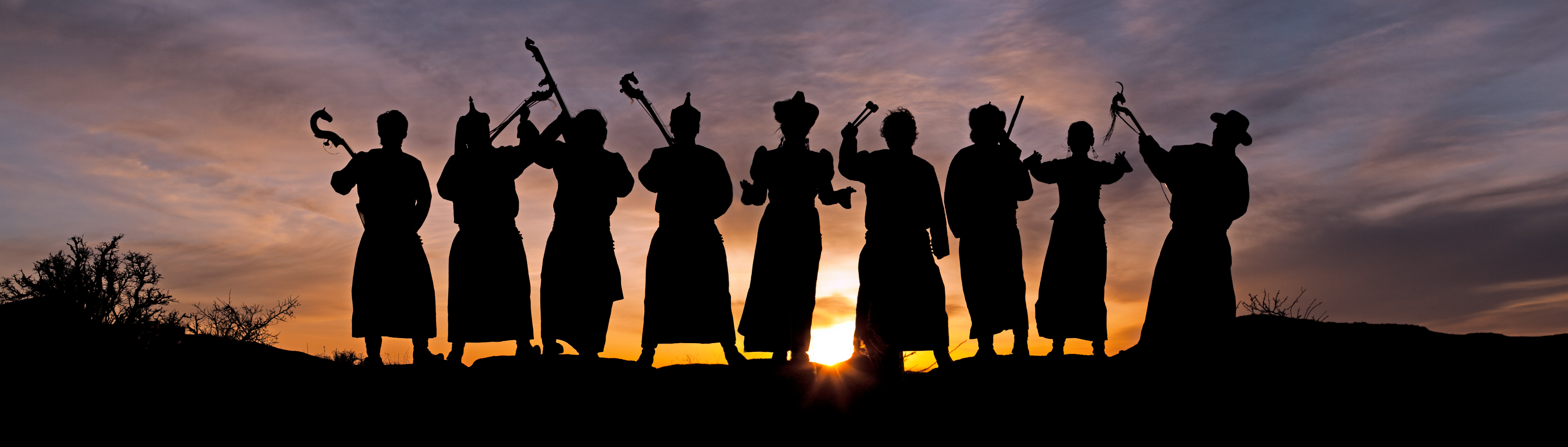 A backlit silhouette of 9 artists holding various musical instruments stand outside. The Global Arts Live green logo is on their left