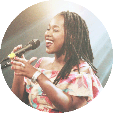 Elida Almeida smiles and sings while holding a microphone
