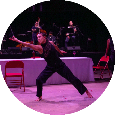 A dancer stretches to the side with her arm reaching out