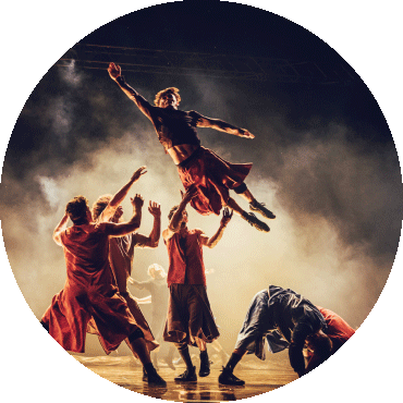 A dancer poses in the air and a group of dancers catches them