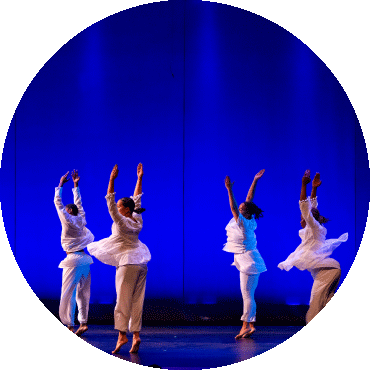 Four dancers spin with their arms up