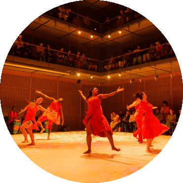 A group of dancers in red perform on stage