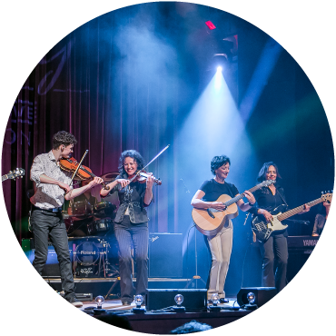 Leahy is captured performing live on stage with blue lighting and smoke