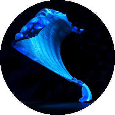 Dancer bends back while hold a large, flowing piece of fabric
