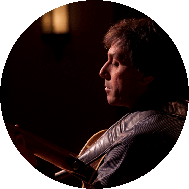 Side profile of Peppino D'Agostino playing the guitar