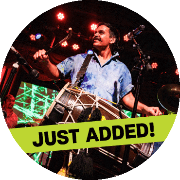 Sunny Jain smiles and plays the dhol drum
