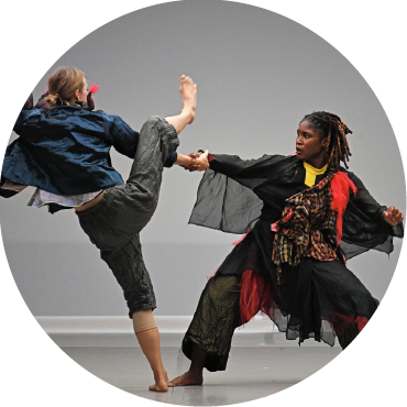 Dancers appear to fight and hold each other on stage.