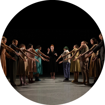 Dancers are captured in a "V" formation in front of a black backdrop