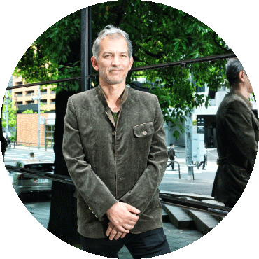 Brad Mehldau stands outside and poses