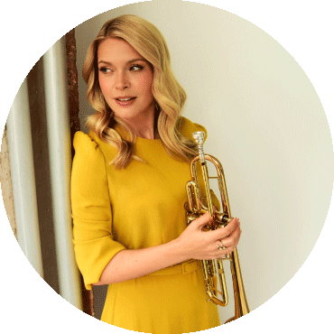 Bria Skonberg poses with her trumpet while looking to the side