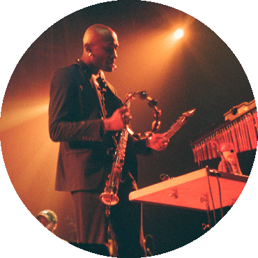 Isaiah Collier holds a tambourine while performing on stage
