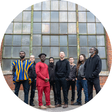 Members of Kotoko Brass pose together in front of a building