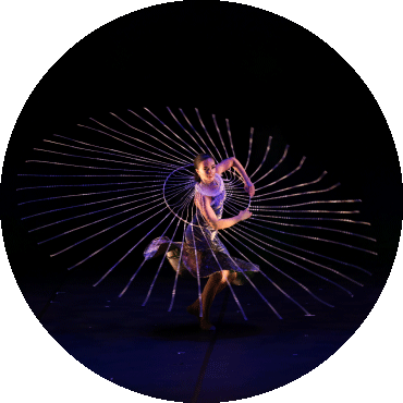 Dancer spins in circle with a lit up object surrounding them