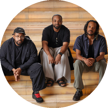 Sullivan Fortner Trio sits and poses on stairs