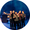 Members of Le Vent du Nord sing on stage.