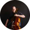 Mike Blocks smiles and looks down at his cello.