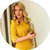 Bria Skonberg poses with her trumpet while looking to the side