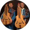 Debashish Bhattacharya and Suryadipta Bhattacharya smile and hold their instruments