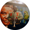 Marquis Hill stands and poses in front of a mural