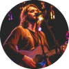 Nicolás Emden performs on stage while holding a guitar