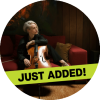 Zoë Keating poses with the cello on top of a red couch.