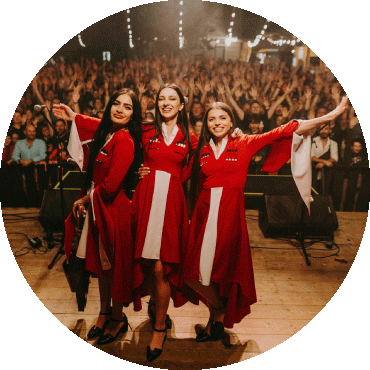 Trio Mandili smiles on stage in front of a crowd